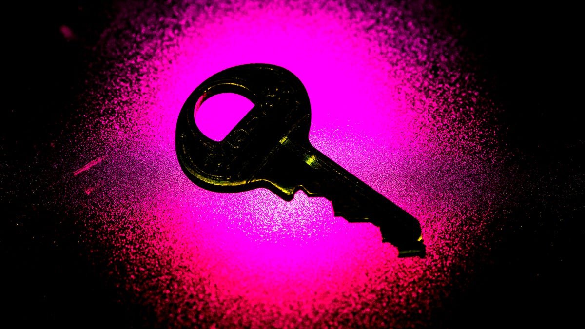 a metal key is backlit by a bright pink light