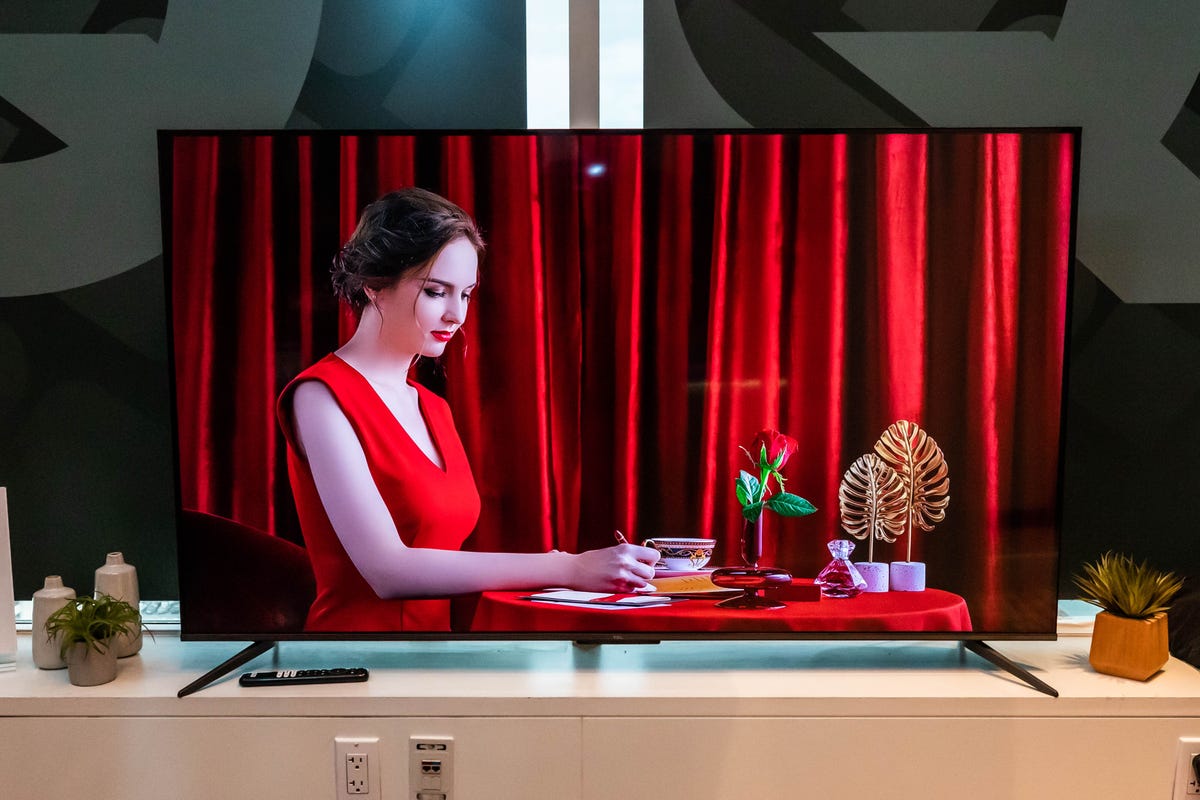 The TCL Q6 Google TV displaying a woman wearing red.