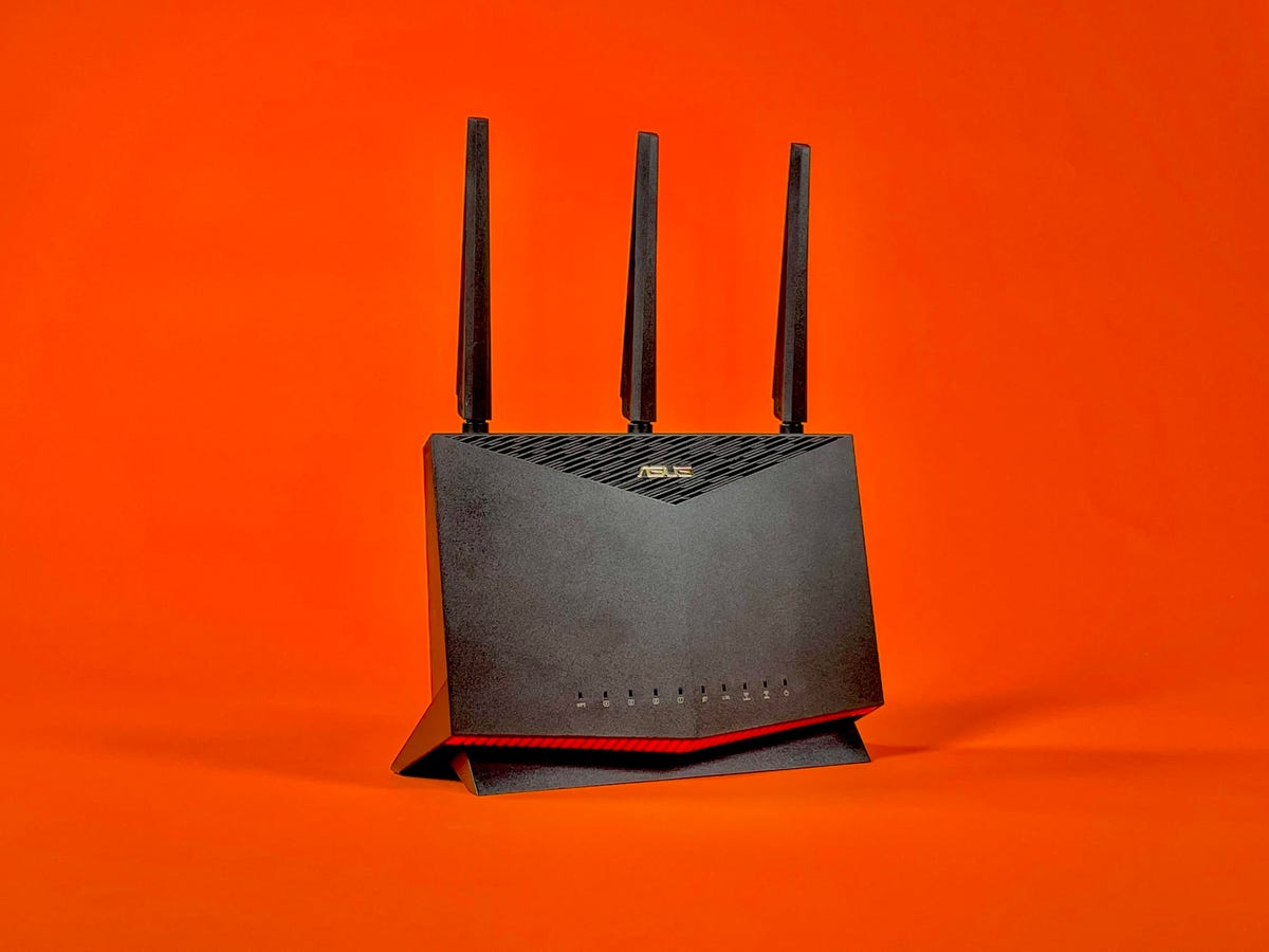 The Asus RT-AX86U Wi-Fi 6 gaming router against a orange background.
