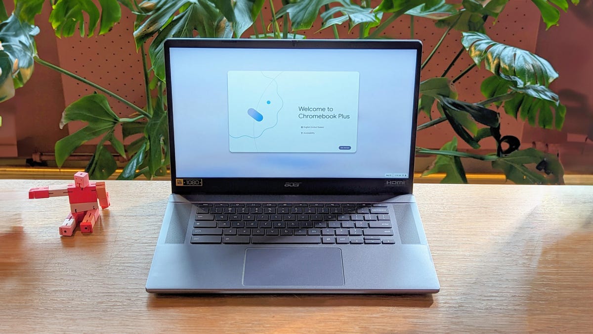 Acer Chromebook Plus 515 open front facing on a wood table with a plant in the background.
