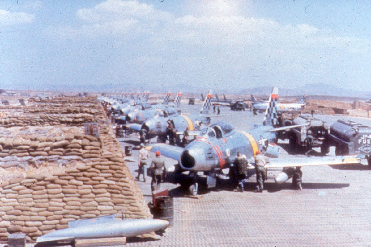 F-86E Sabre aircraft lined up at an airfield for service