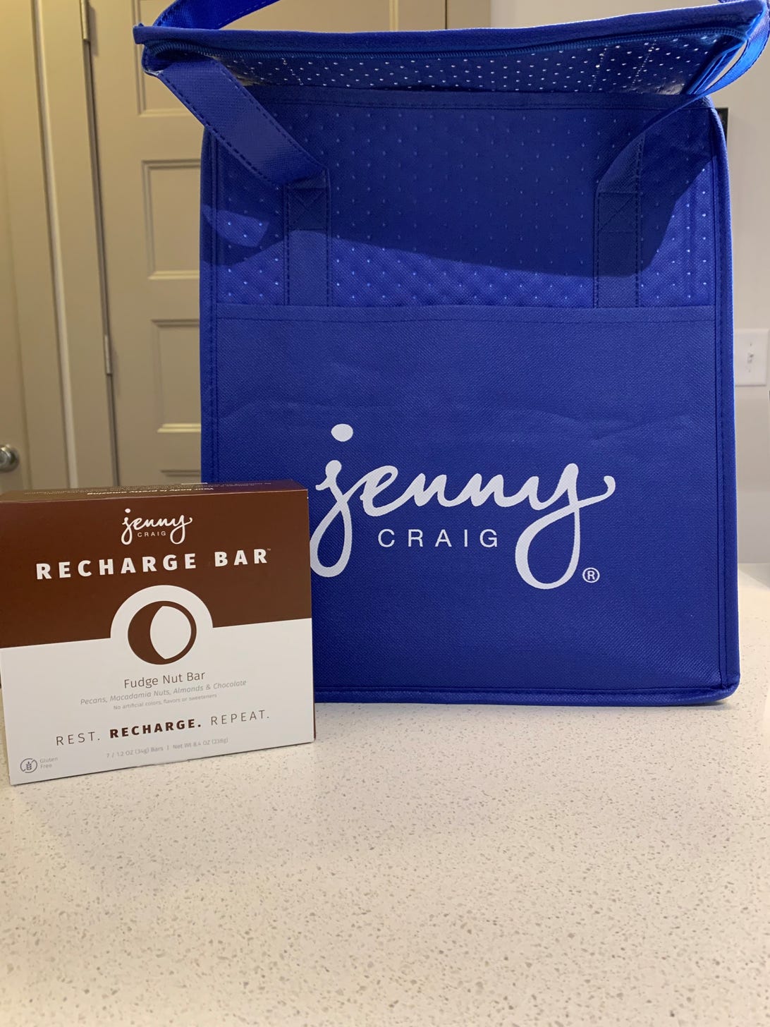a brown and white box of recharge bars, and a blue tote