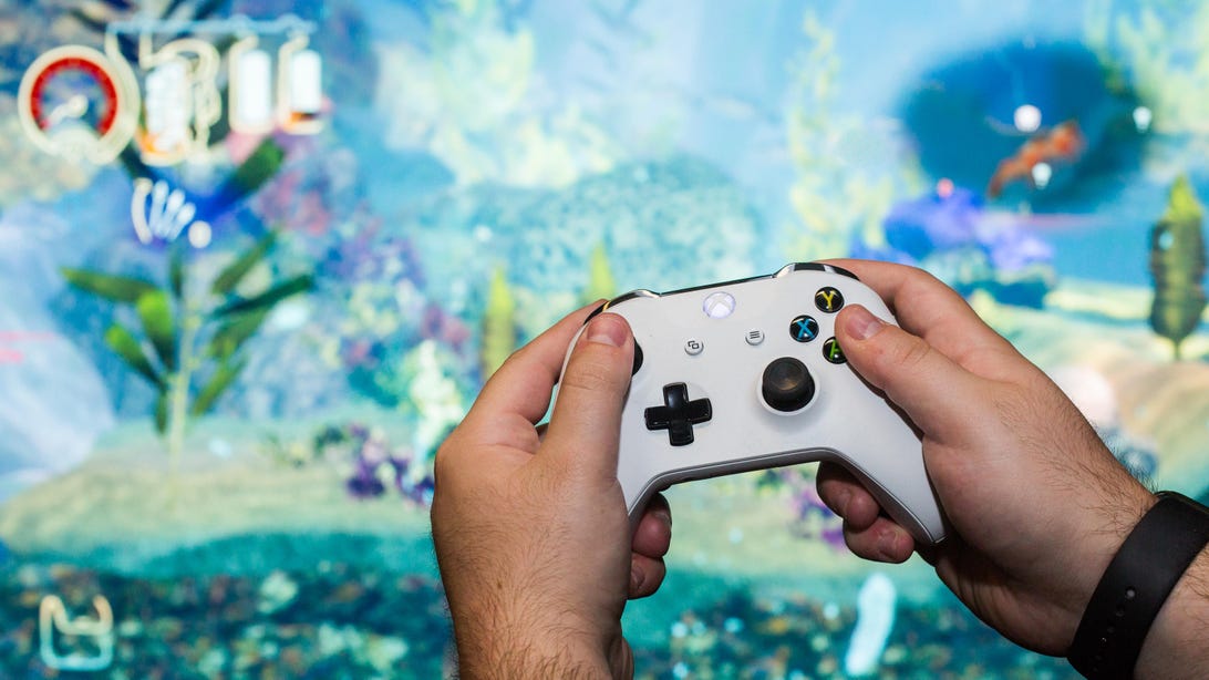 A person holds an Xbox One controller while playing Shinsekai Into the Depths