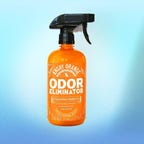 A bottle of Angry Orange pet odor eliminator spray is displayed against a blue background.