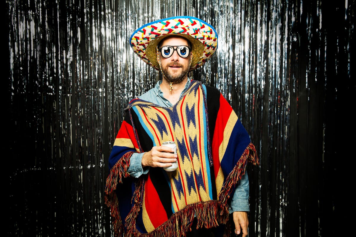 Man dressed up in sombrero and serape with silly glasses