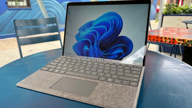 Un Microsoft Surface Pro 8 sentado en una mesa azul afuera. Mejores computadoras portátiles