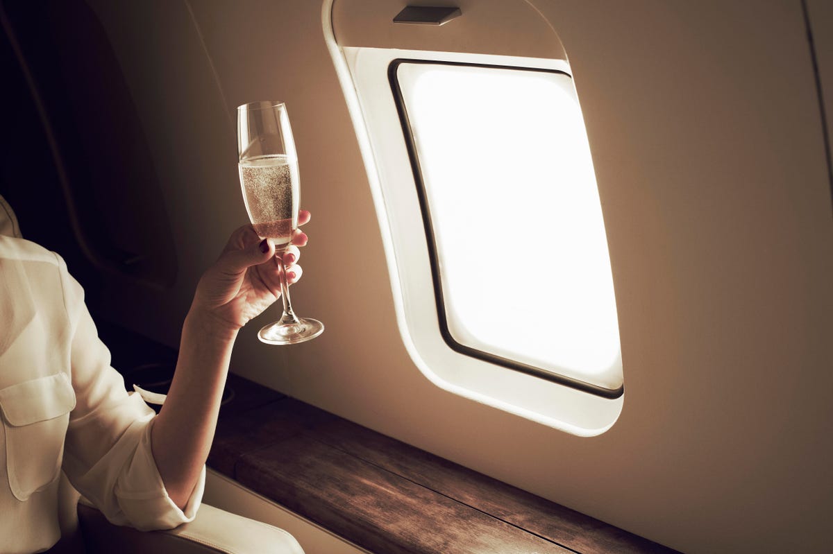 Champagne in a glass in front of an airplane window