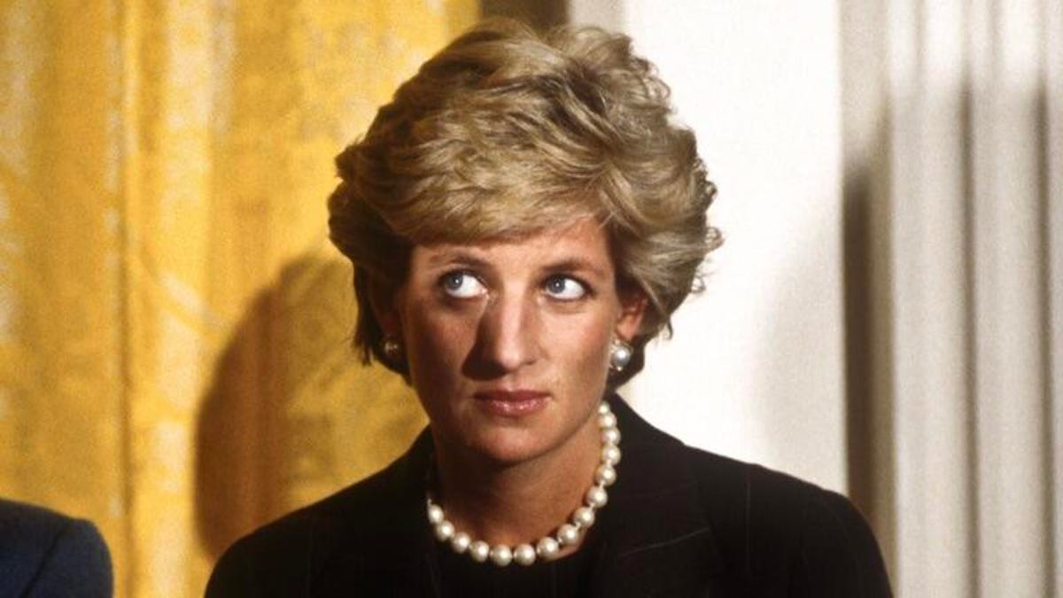 Diana, Princess of Wales wears a black top and pearl necklace.