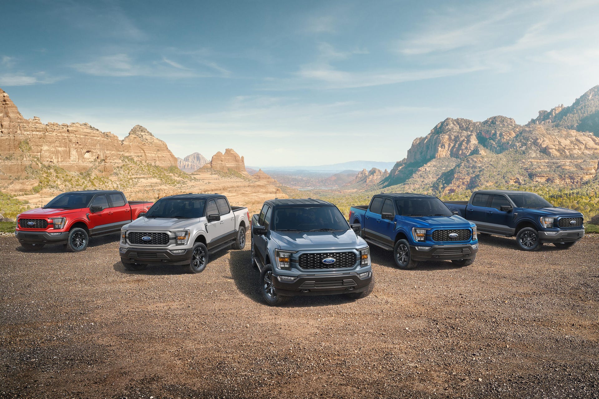 Five 2023 Ford F-150 Heritage Edition pickup trucks lined up in front of a canyon range