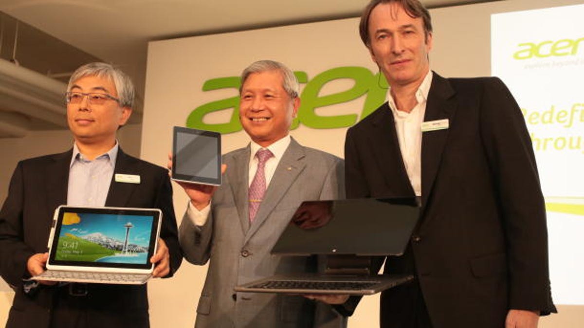Acer President Jim Wong (from left), Acer Chairman J.T. Wang, and another executive unveil new touch-screen products.