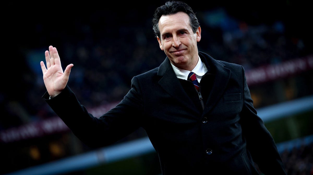 Aston Villa manager Unai Emery, smiling, waving with his right hand.