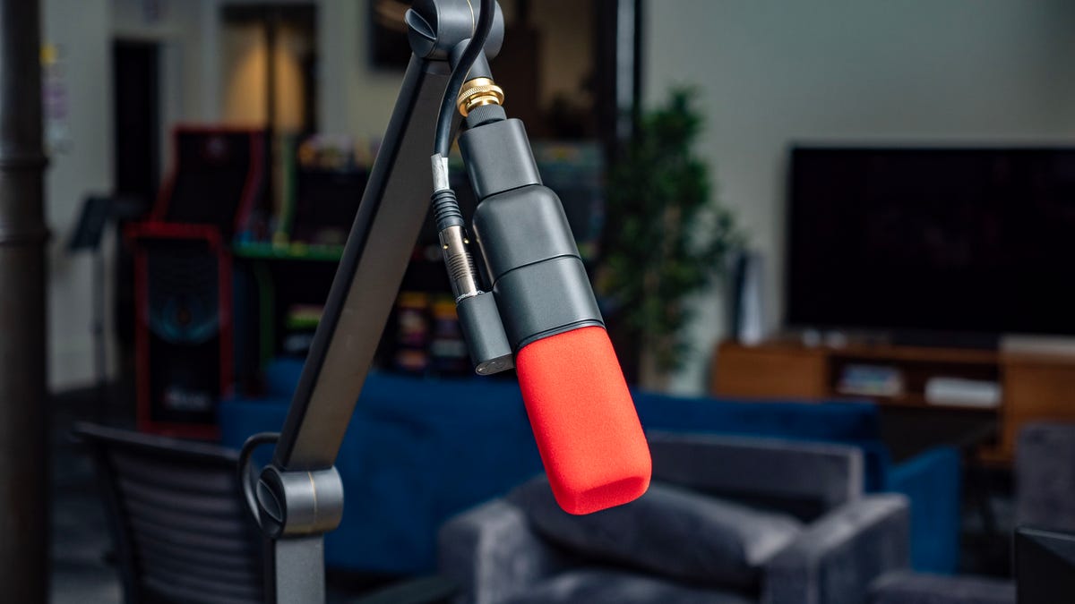 Logitech Blue Sona microphone attached to a desk arm in an office.