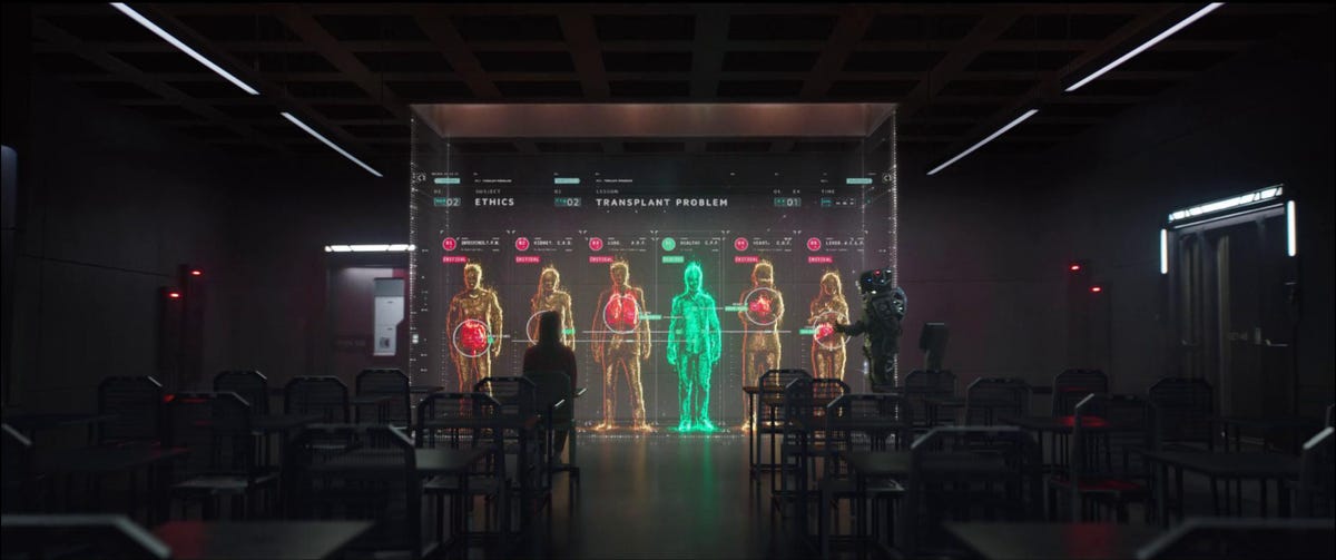 A holographic screen sits in the center of a room with an ethics thought experiment on it. A robot stands to the right and a girl is sitting in a classroom-like seat in front of the holographic screen.
