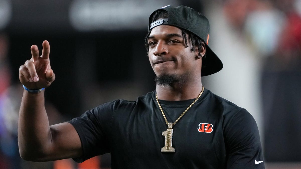 Cincinnati Bengals wide receiver Ja'Marr Chase wearing a baseball cap backwards gesturing with two raised figures on his right hand.