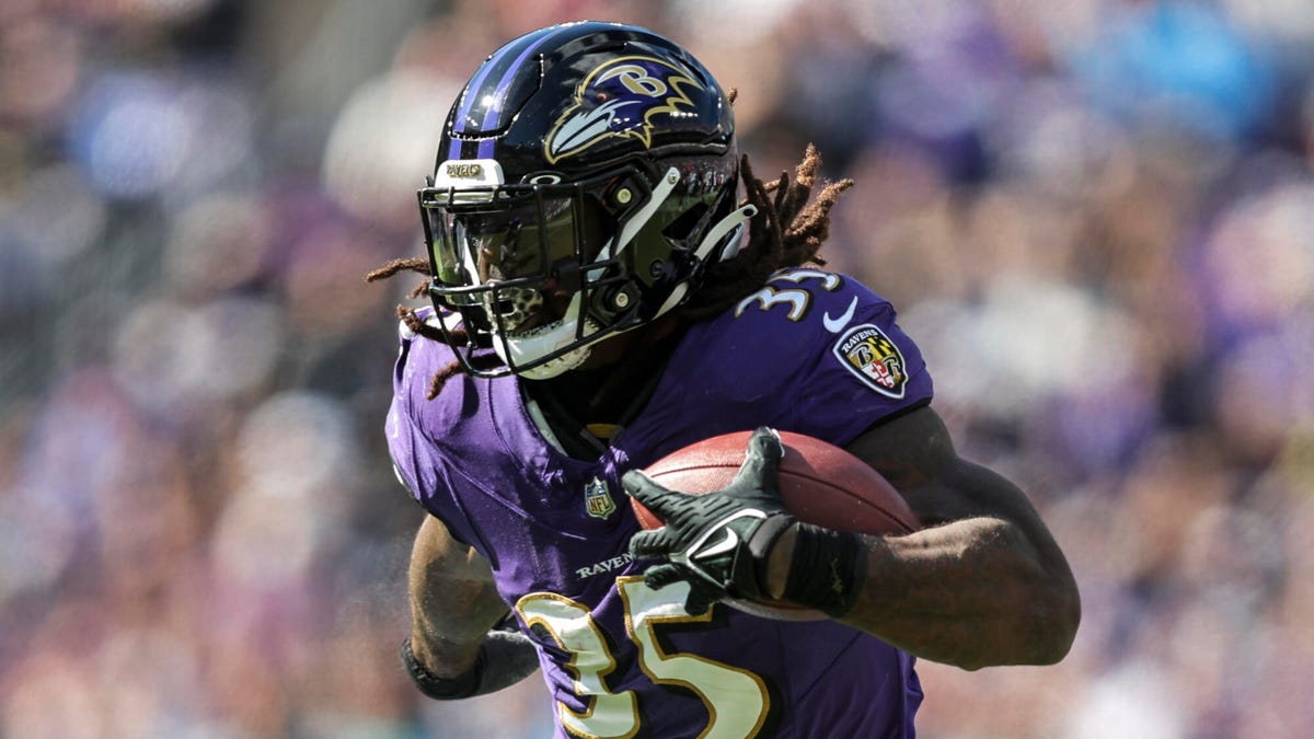 Gus Edwards of the Baltimore Ravens running with the ball under his left arm.