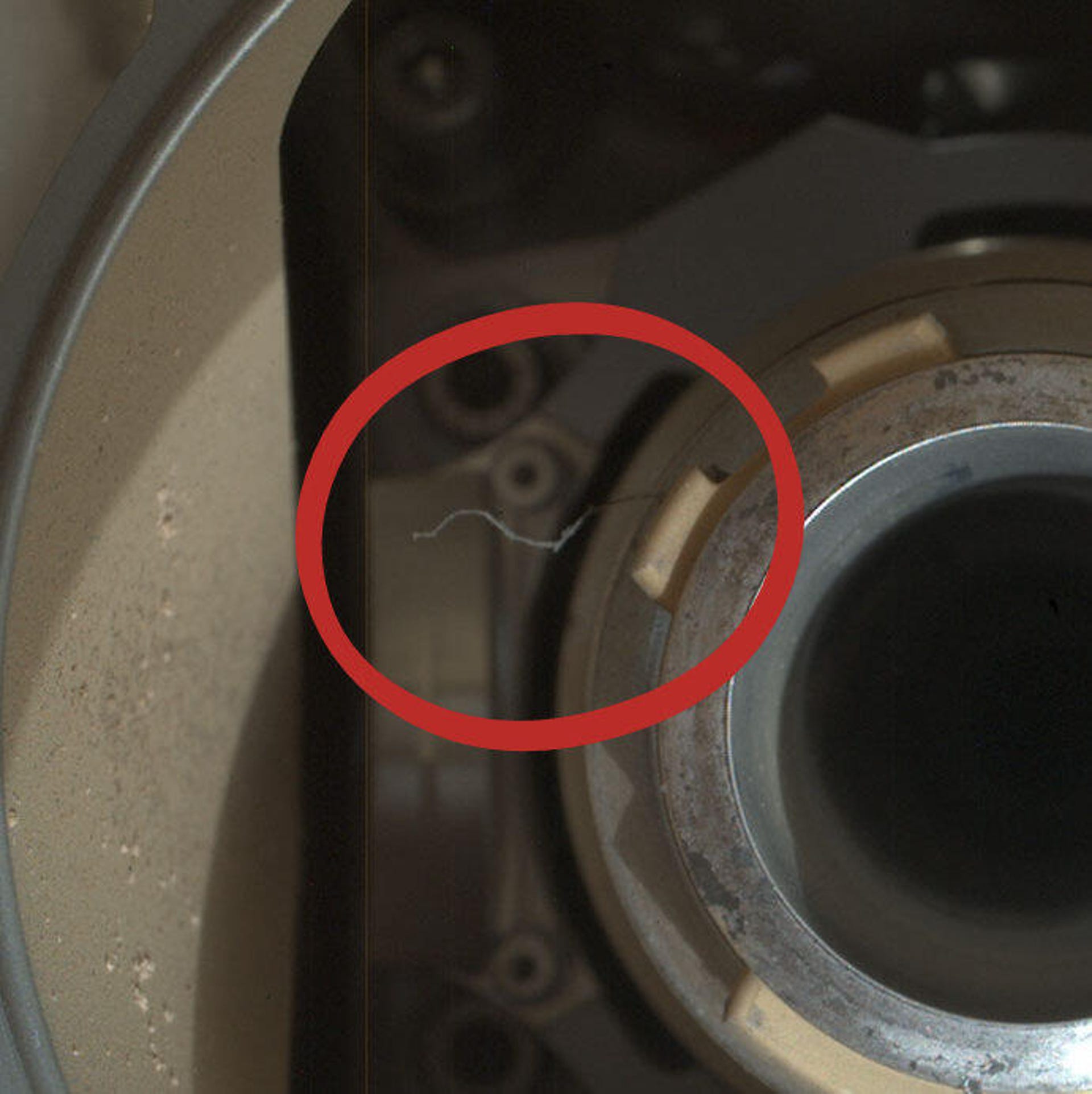 Close up view of tiny thread-like object on drill chuck of Perseverance rover.