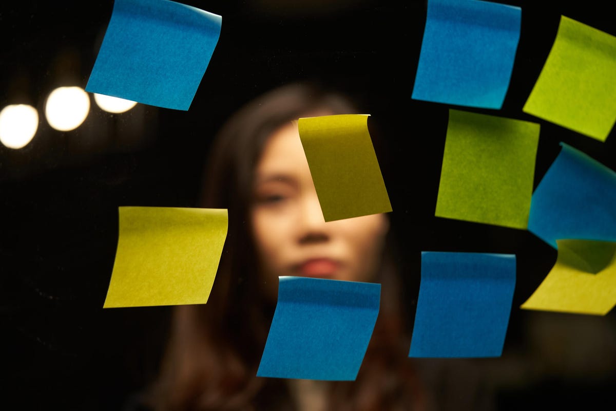 Woman looking at post-it notes.