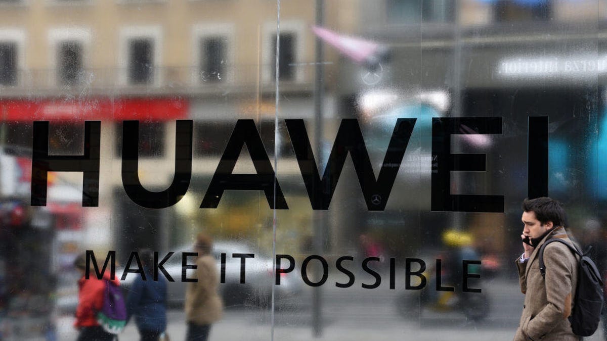 A pedestrian talking on phone seen walking past a new Huawei