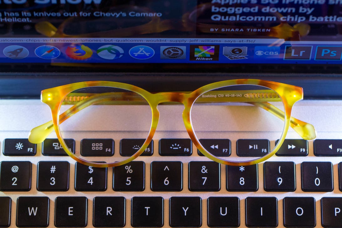 Blue light glasses resting on a laptop keyboard