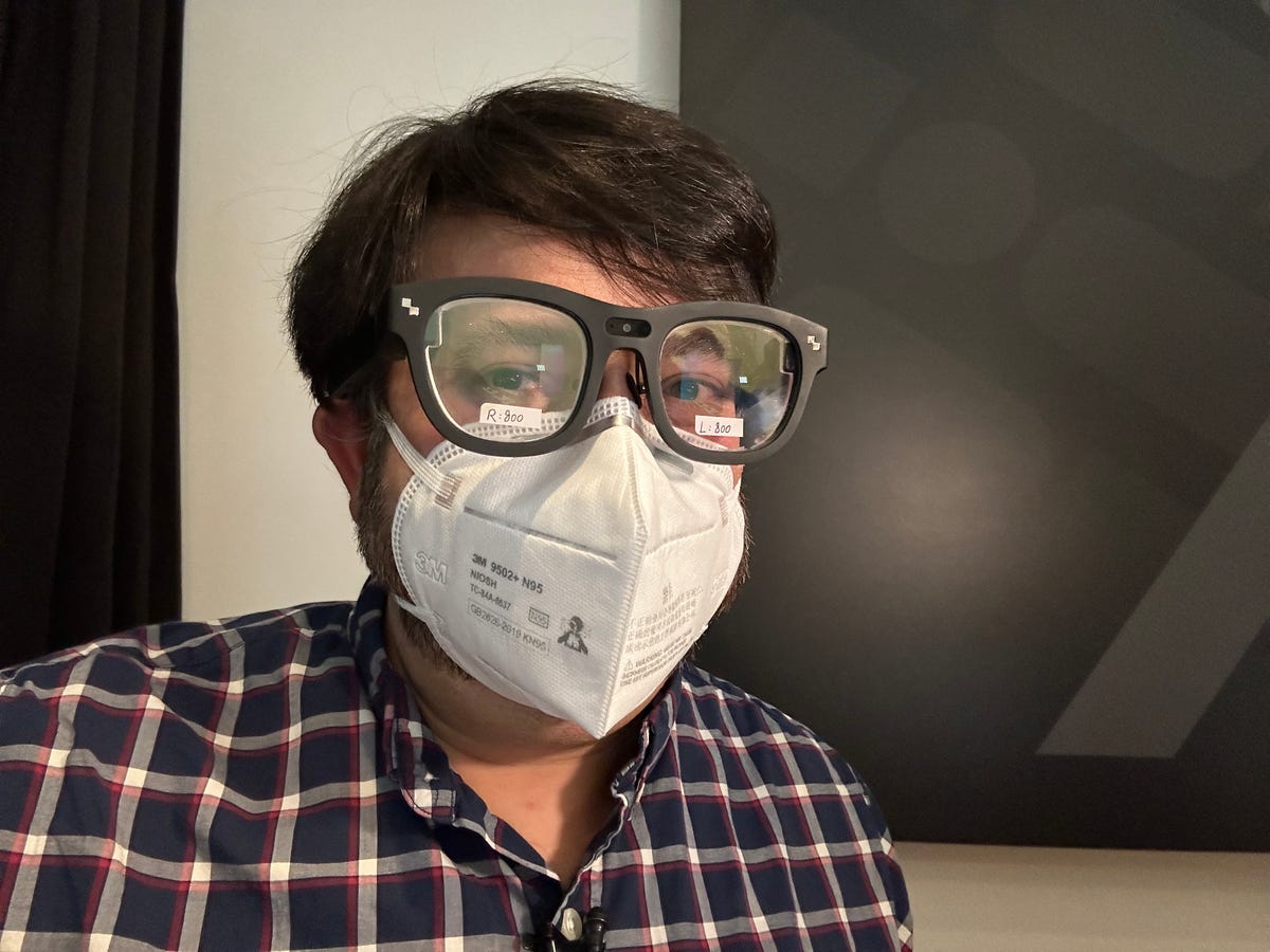 A man wearing an N95 mask and a pair of large black AR glasses