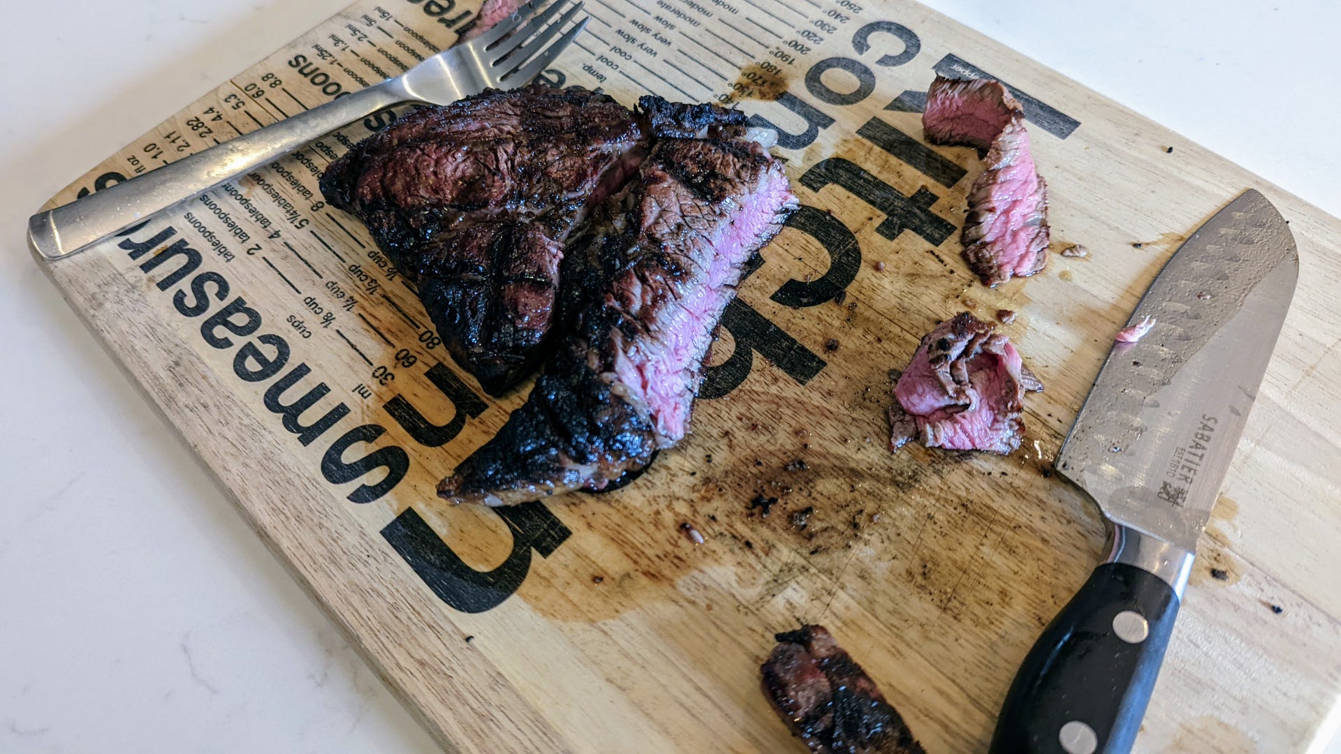 Charred pink steak sliced on a cutting board