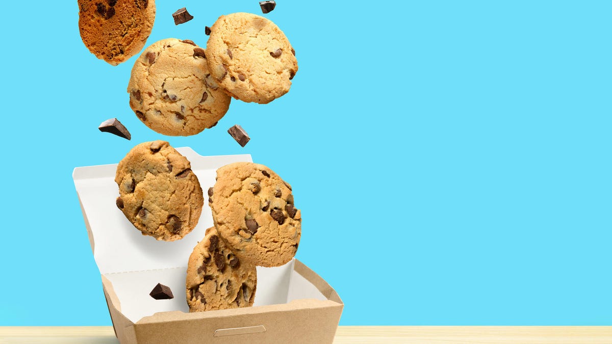 Chocolate chip cookies falling into a box