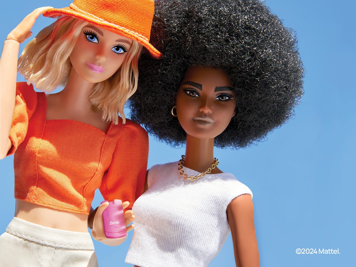 Barbie preta e Barbie branca, com Barbie branca segurando um telefone
