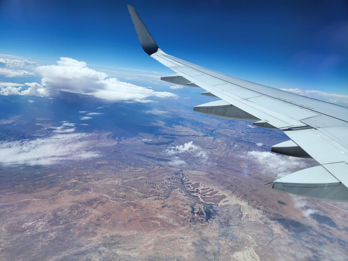 Imagen de nubes y tierra tomada desde la ventana de un avión