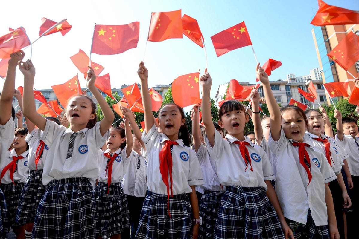 Chinese schoolchildren wave Chinese flags