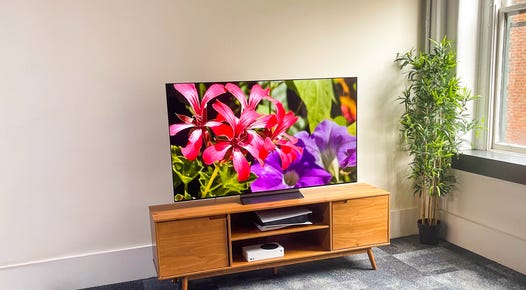 LG C2 OLED TV in a bright room on a wooden TV stand