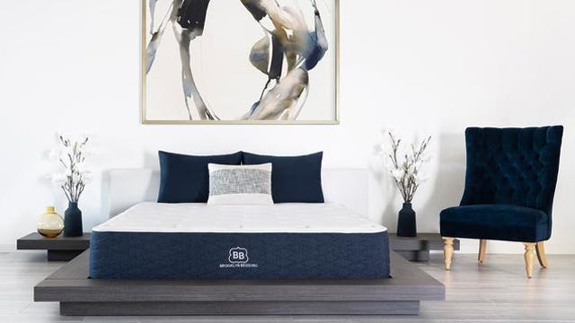 Signature mattress from Brooklyn Bedding next to a blue armchair