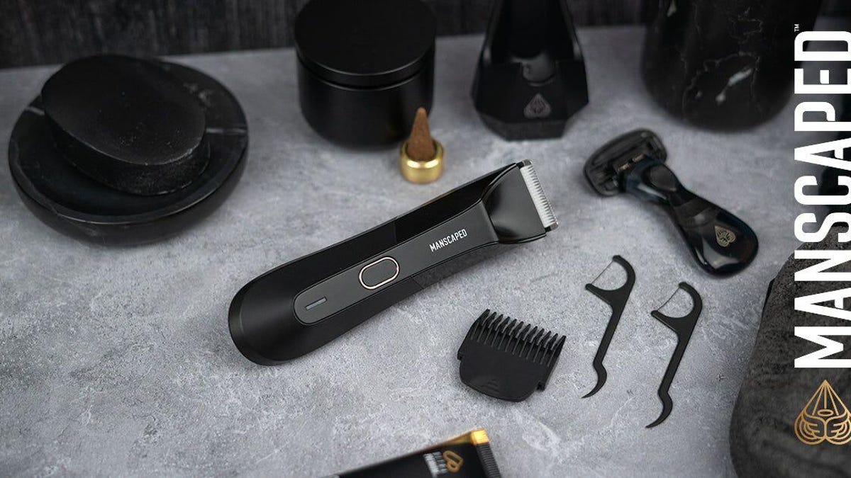 A Manscaped Lawnmower electric razor surrounded by other shaving accessories.