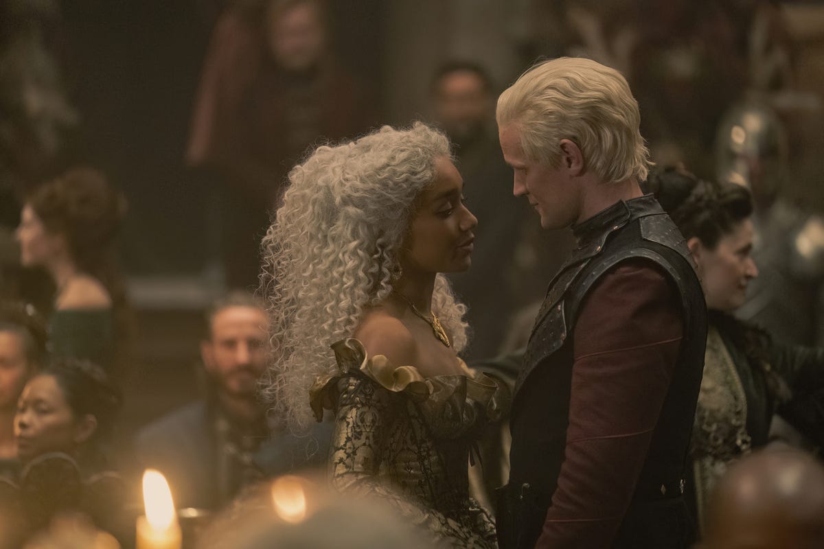 Laena Valeryon and Daemon Targaryen dancing in a hall filled with people