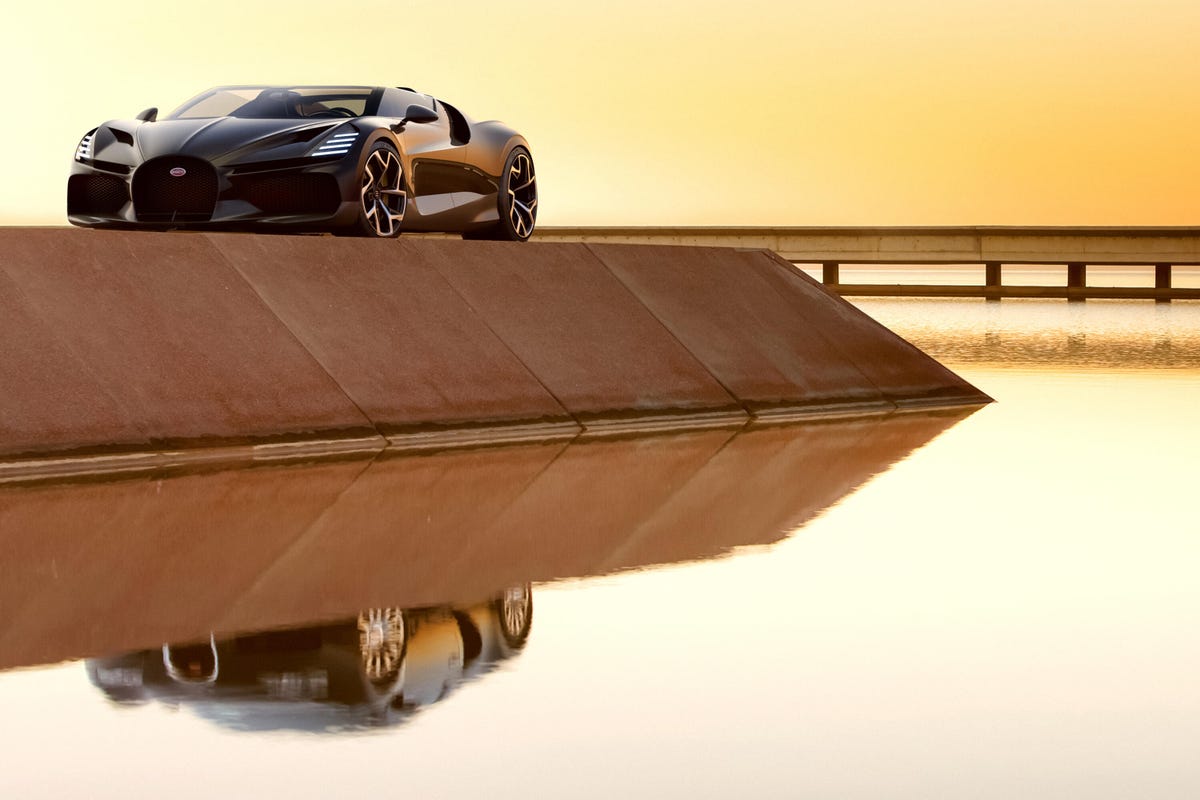 Front 3/4 view of a Bugatti W16 Mistral with a Bugatti Veyron shown in the reflection