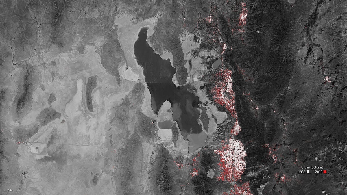 Black-and-white satellite image of the Great Salt Lake and Salt Lake City, showing huge urban expansion in red.