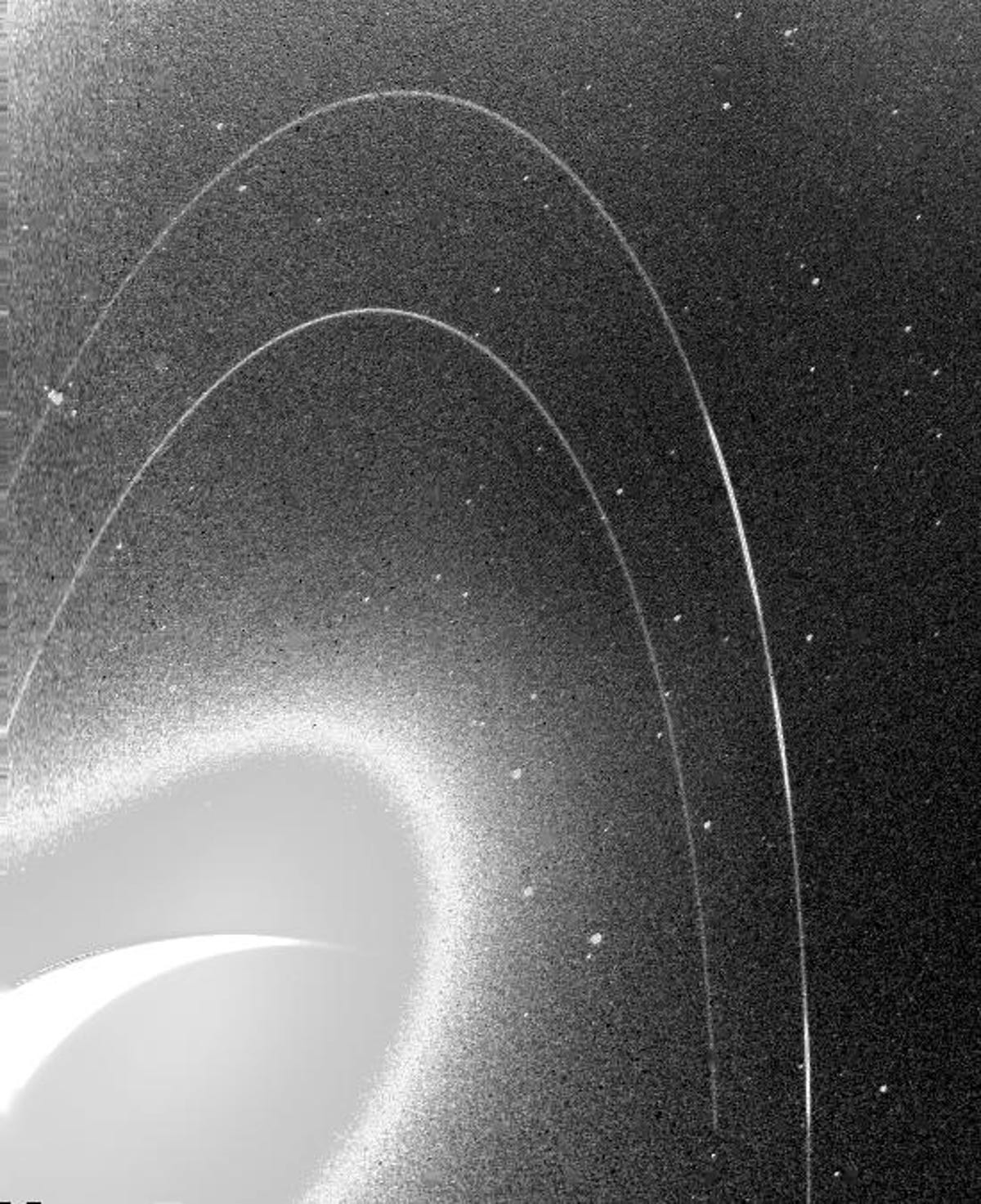 A grainy, black and white image shows Neptune's frail rings.