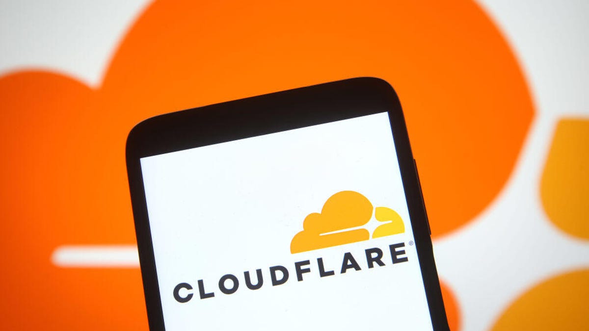 Cloudflare logo on phone, against a larger version of its logo in the background