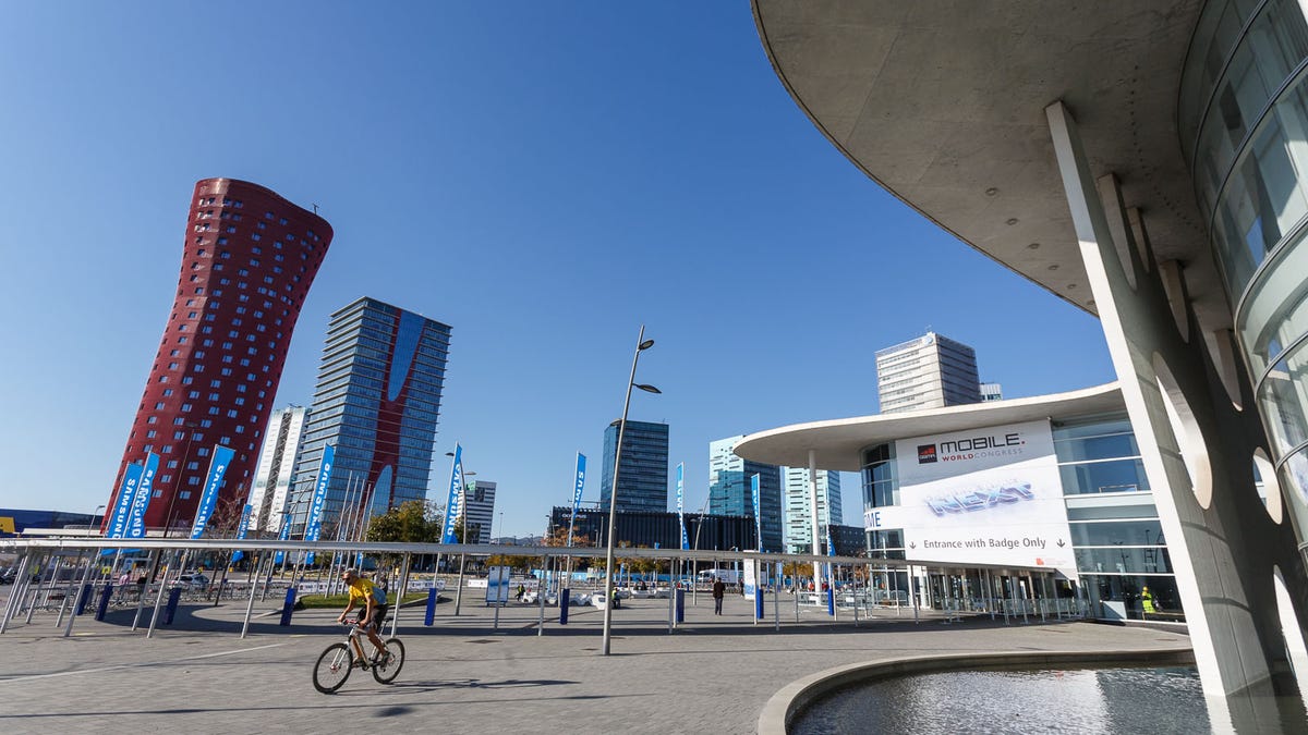 A cyclist rides past the Mobile World Congress entrance, still empty before the throngs of attendees arrive Monday.