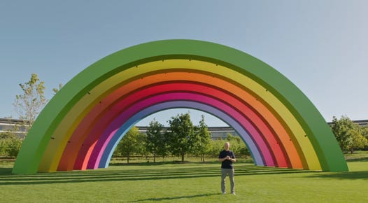 wwdc tim cook stands in front of large rainbow prop