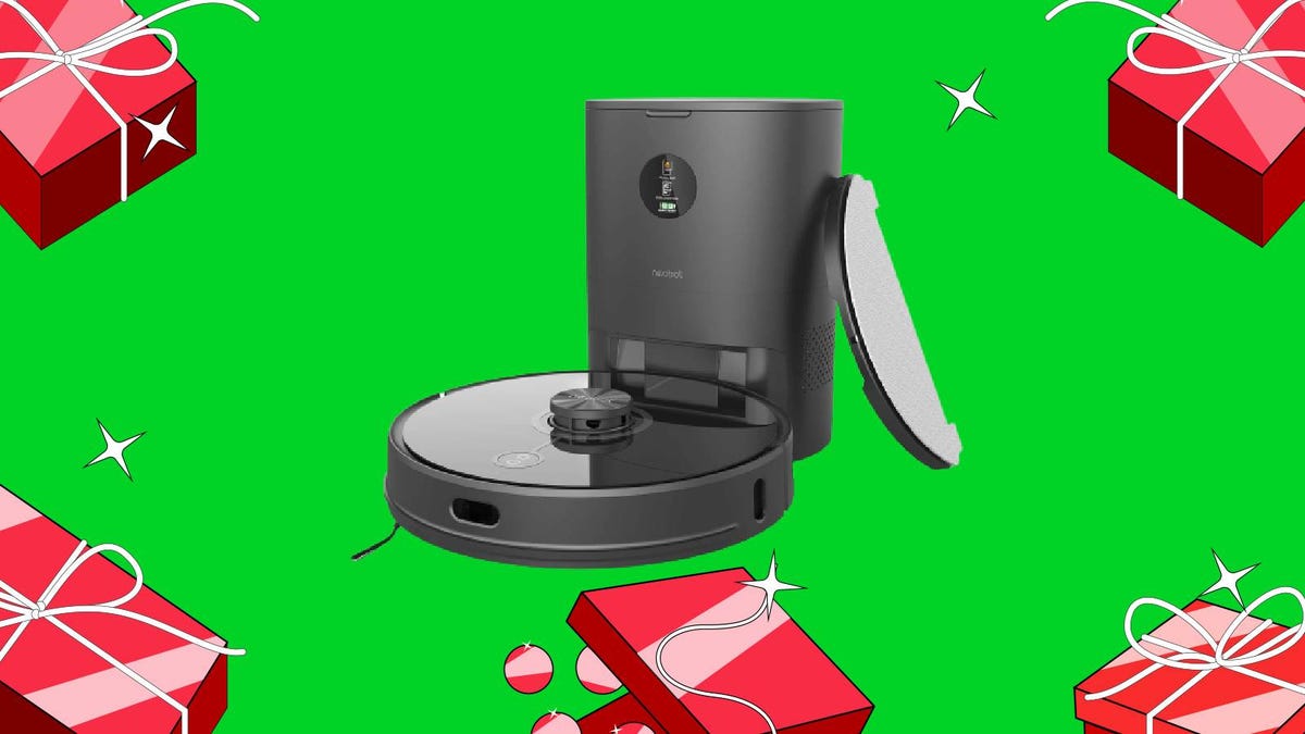 A robot vacuum and self-emptying base against a green background surrounded by red wrapped presents.