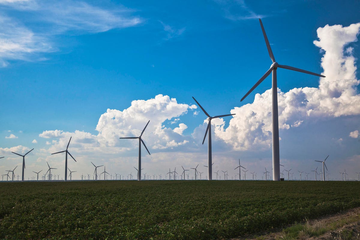 Wind turbines in field against blue sky with clouds in Abilene, Texas.