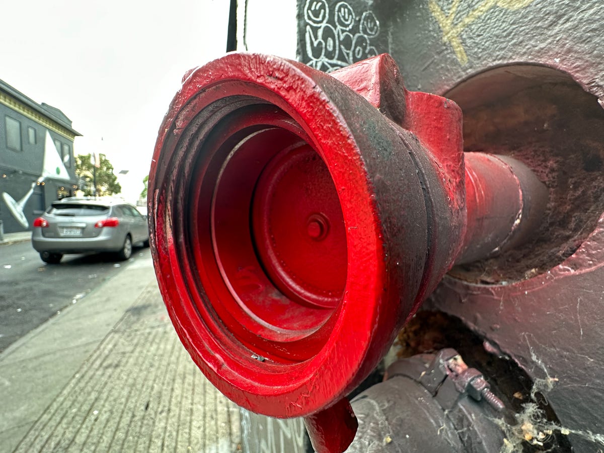 A red drain pipe on the side of a building