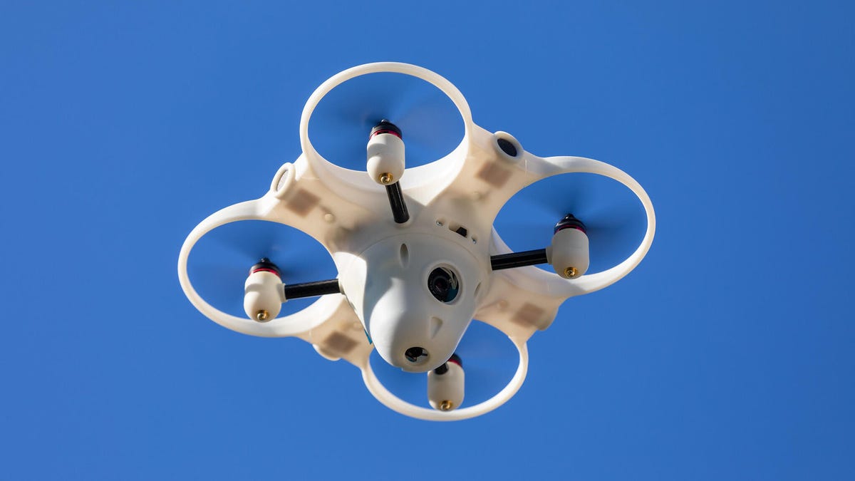 A drone from drone security company Sunflower Labs hovers in a blue sky
