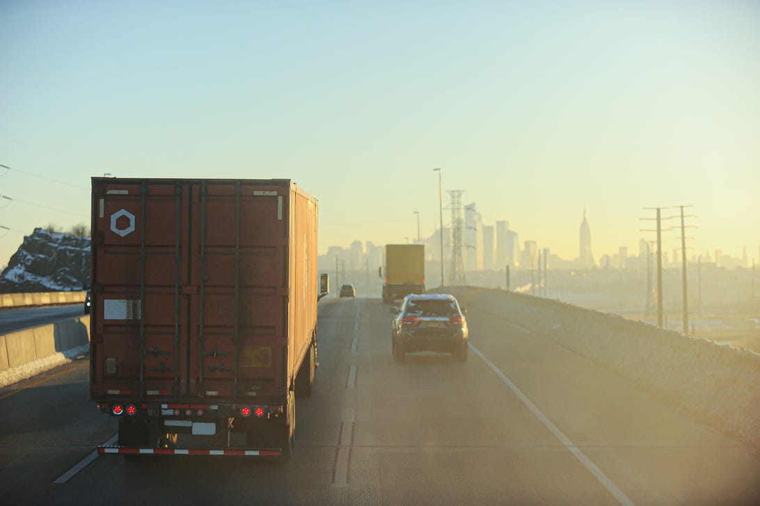 Trucks on a highway amid smog.