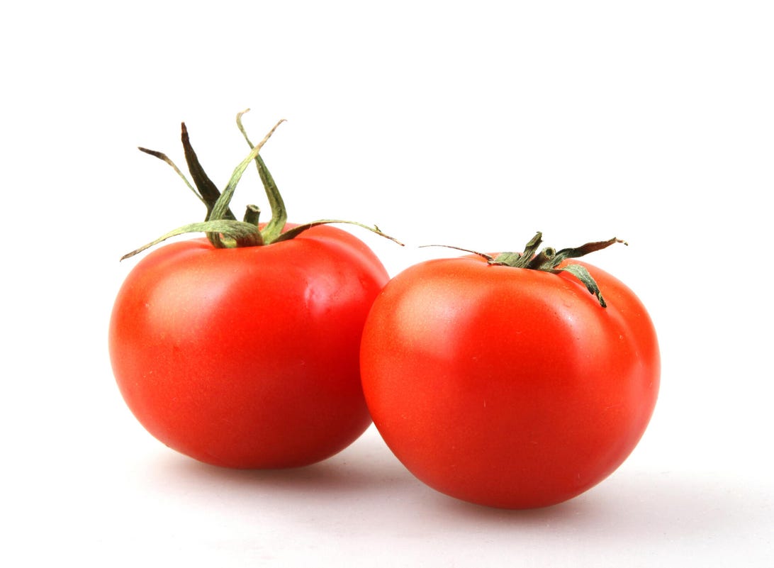 two ripe tomatoes on a white background