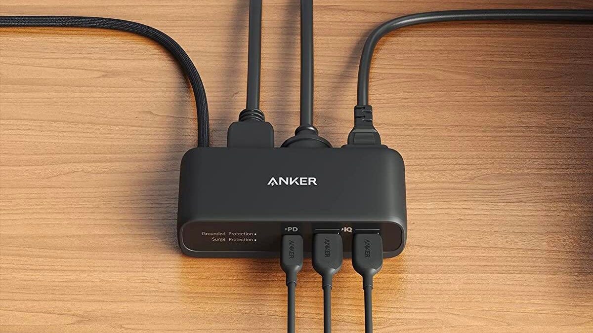A black Anker USB power strip on a wooden table.