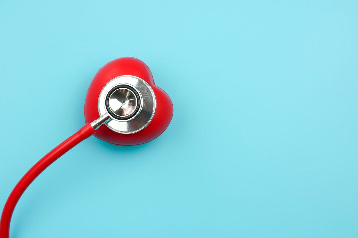 A red heart-shaped stethoscope on a teal background.