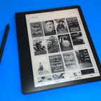 The Kindle Scribe and a stylus on a blue background