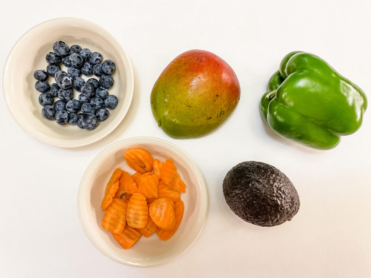 Five servings of produce: half cup of blueberries, half a mango, one bell pepper, one avocado, half cup of carrots