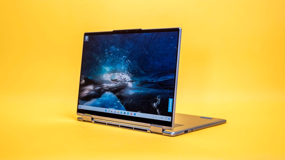 Lenovo Yoga 7i Gen 7 14-inch two-in-one laptop in stand mode with the display facing left on a yellow background.